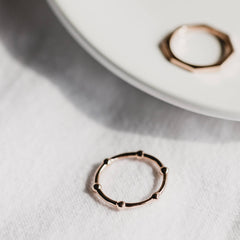 A beaded wire ring made from rose gold and a hexagonal shaped ring made from rose gold