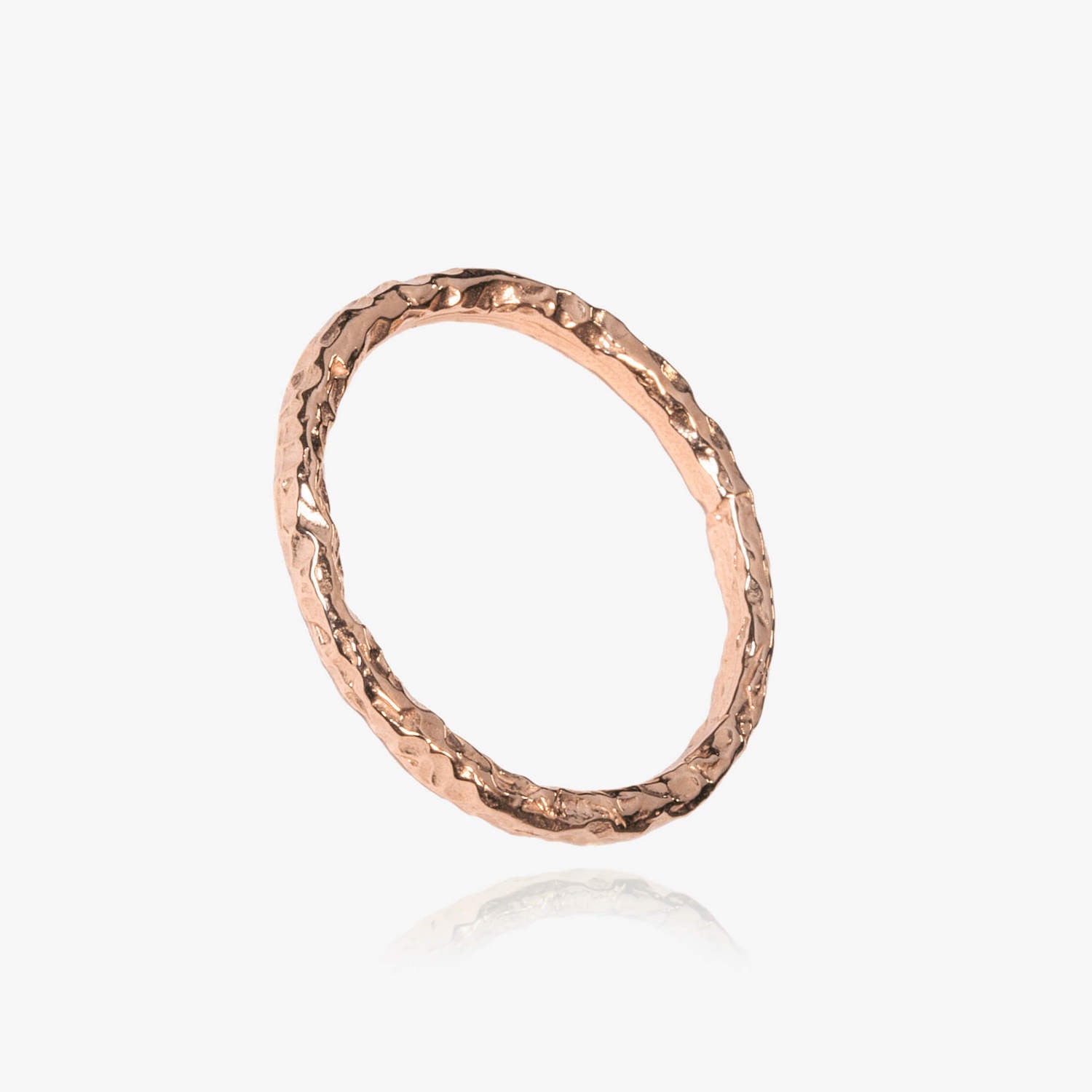 Close up of a rose gold ring with a hammered, meteorite style textured effect
