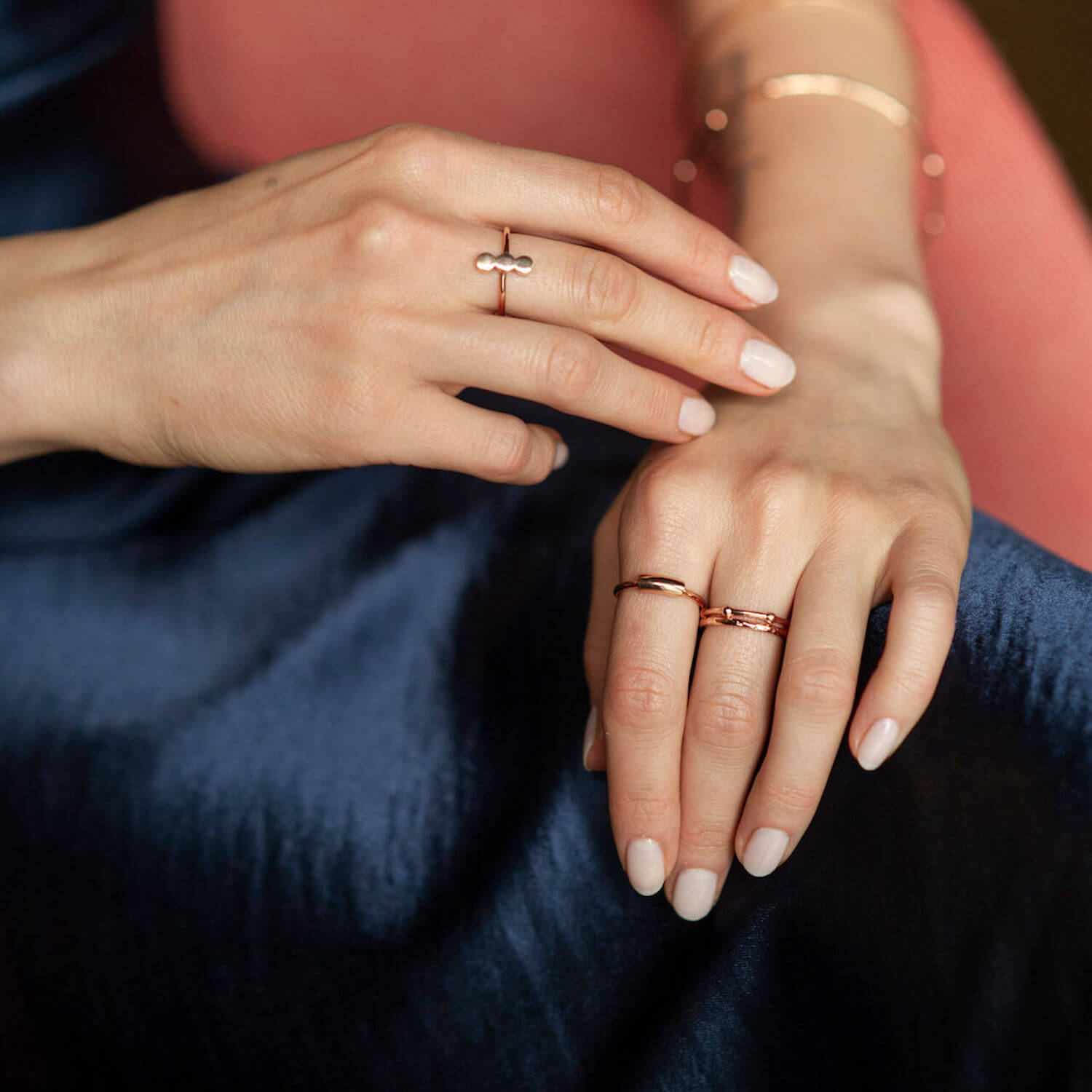 A woman wearing several rose gold Matthew Calvin rings