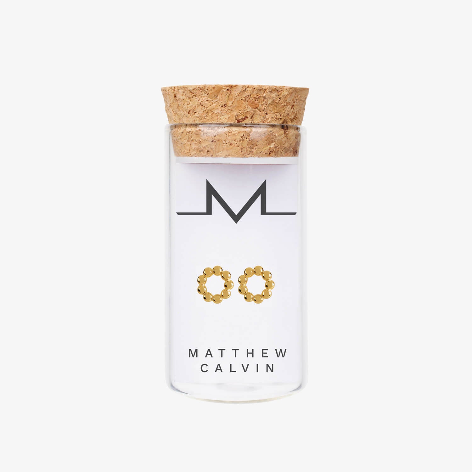 gold vermeil beaded circular studs by matthew calvin presented in a glass tube with a cork stopper on a white background