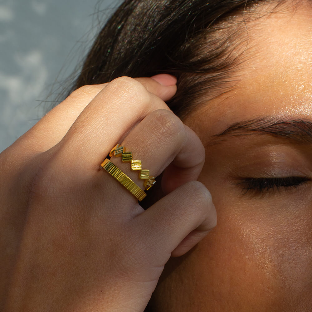 Close up of model wearing Matthew Calvin Doru Ring and Telos Ring in gold