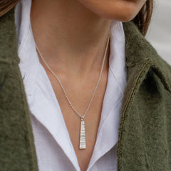 Close up of silver necklace being worn by woman