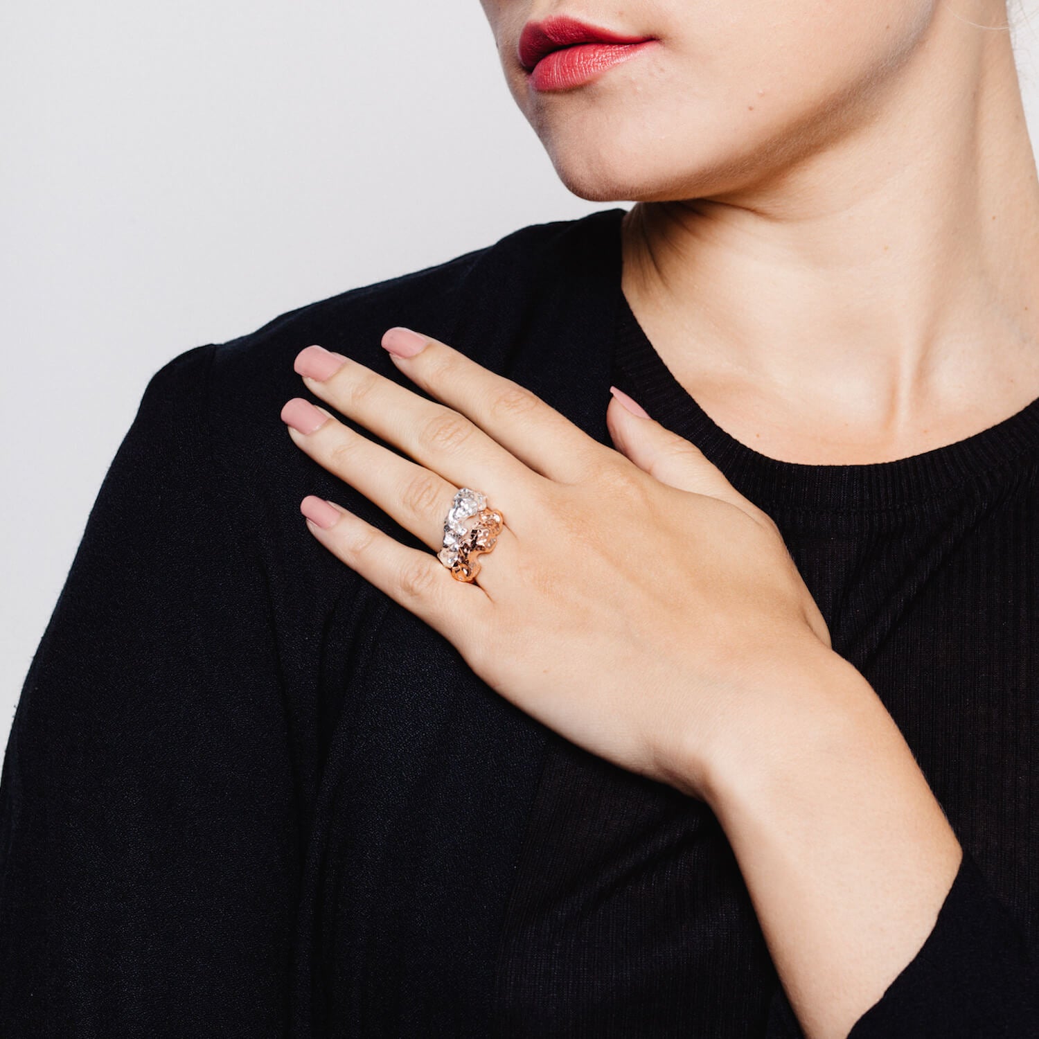 Model wearing two textured rings, one in silver and one in rose gold
