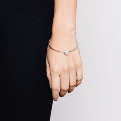 Close up of model wearing thin bangle with large textured charm