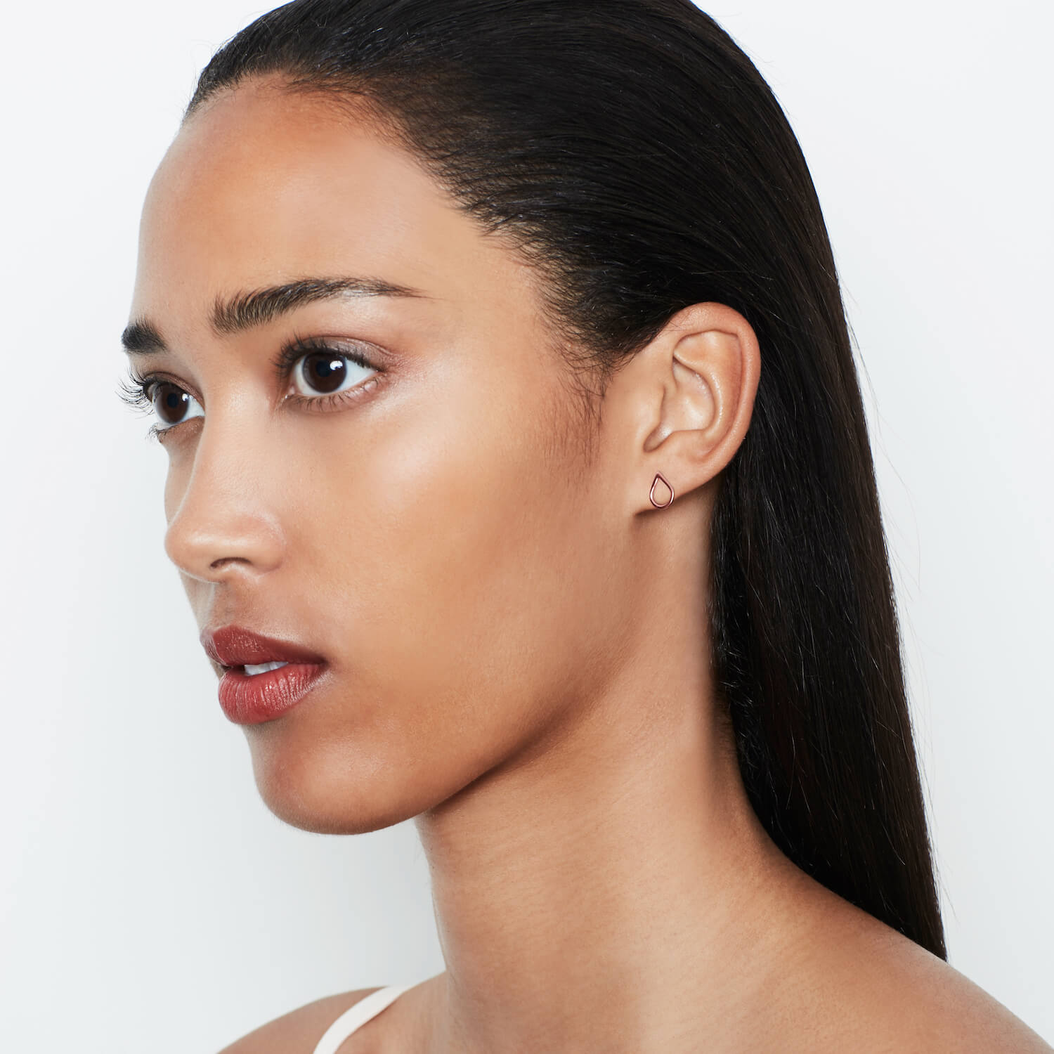 A model wearing rose gold droplet shaped earrings