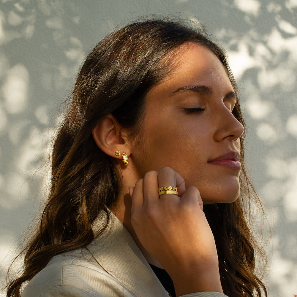 Model wearing lots of jewellery including two rings, a hoop and an earring