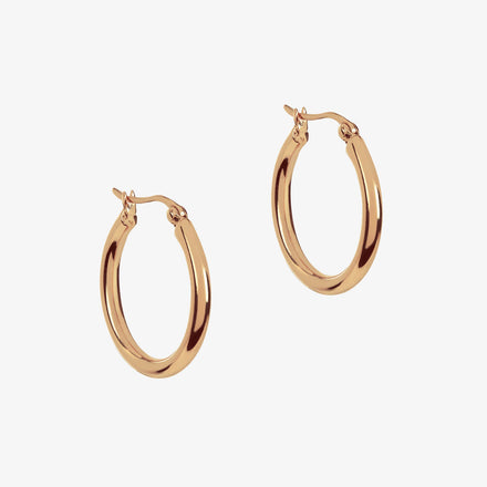 Large rose gold hoops on a white background
