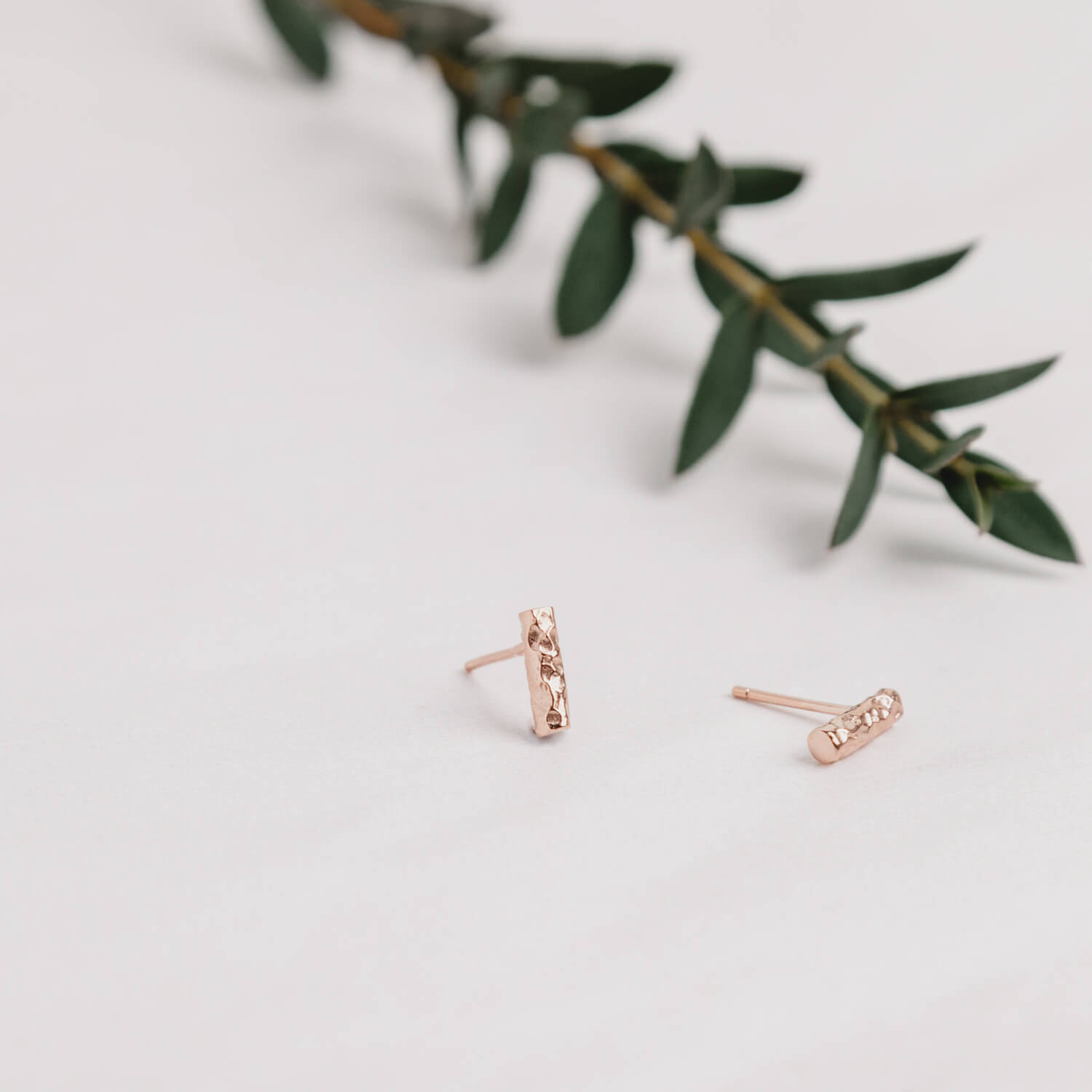 Close up of rose gold Small Meteorite Bar Earrings