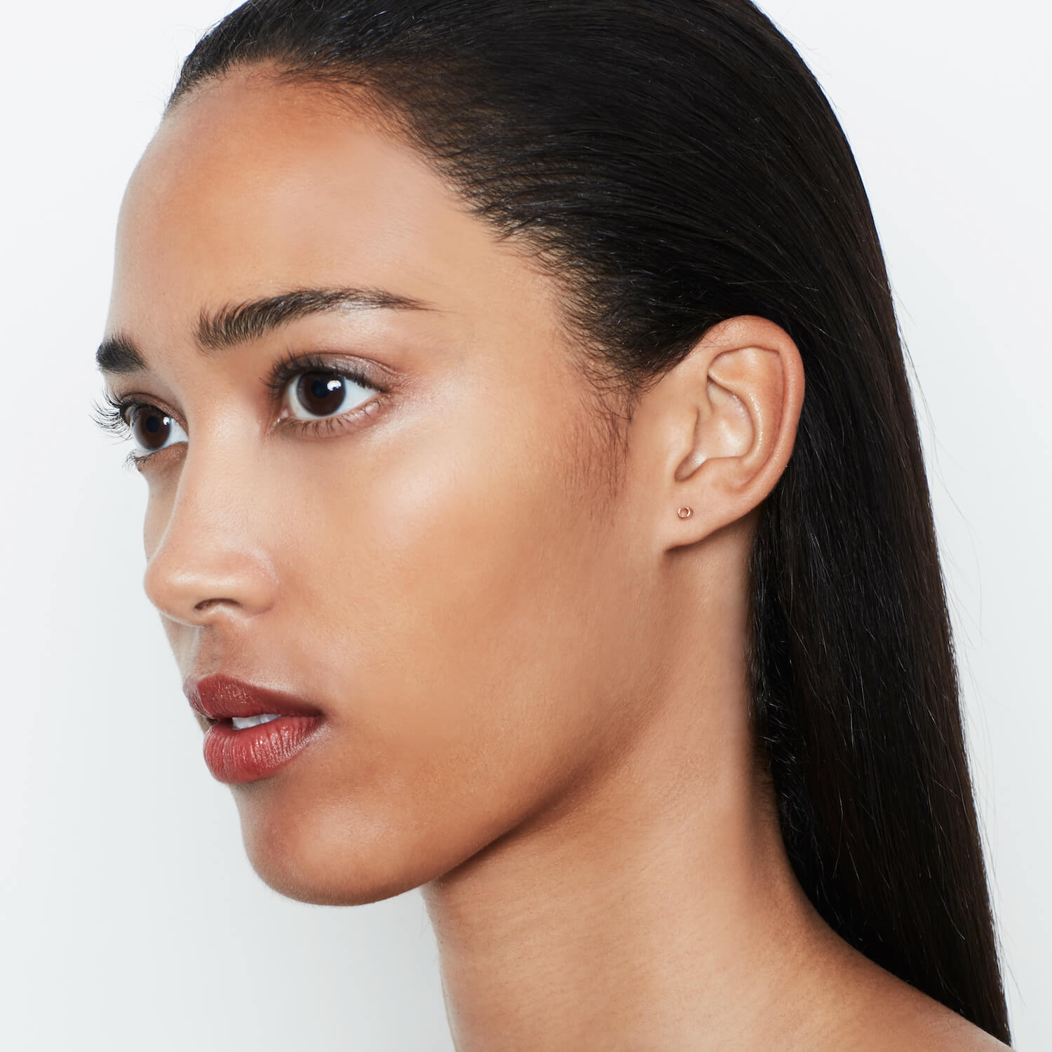 Female model wearing matthew calvin tiny tube earrings in rose gold