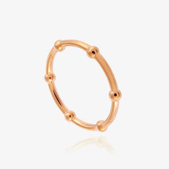 A rose gold ring made from beaded wire on a white background