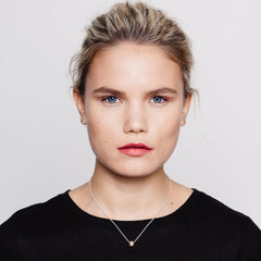 Model wearing small meteorite charm pendant on silver chain