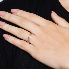 Close up of a woman's hand wearing two rings with a textured, hammered effect