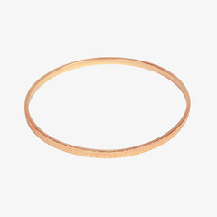 Rose gold textured bangle on a white background
