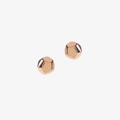 Rose gold dodecahedron shaped studs on a white background by Matthew Calvin