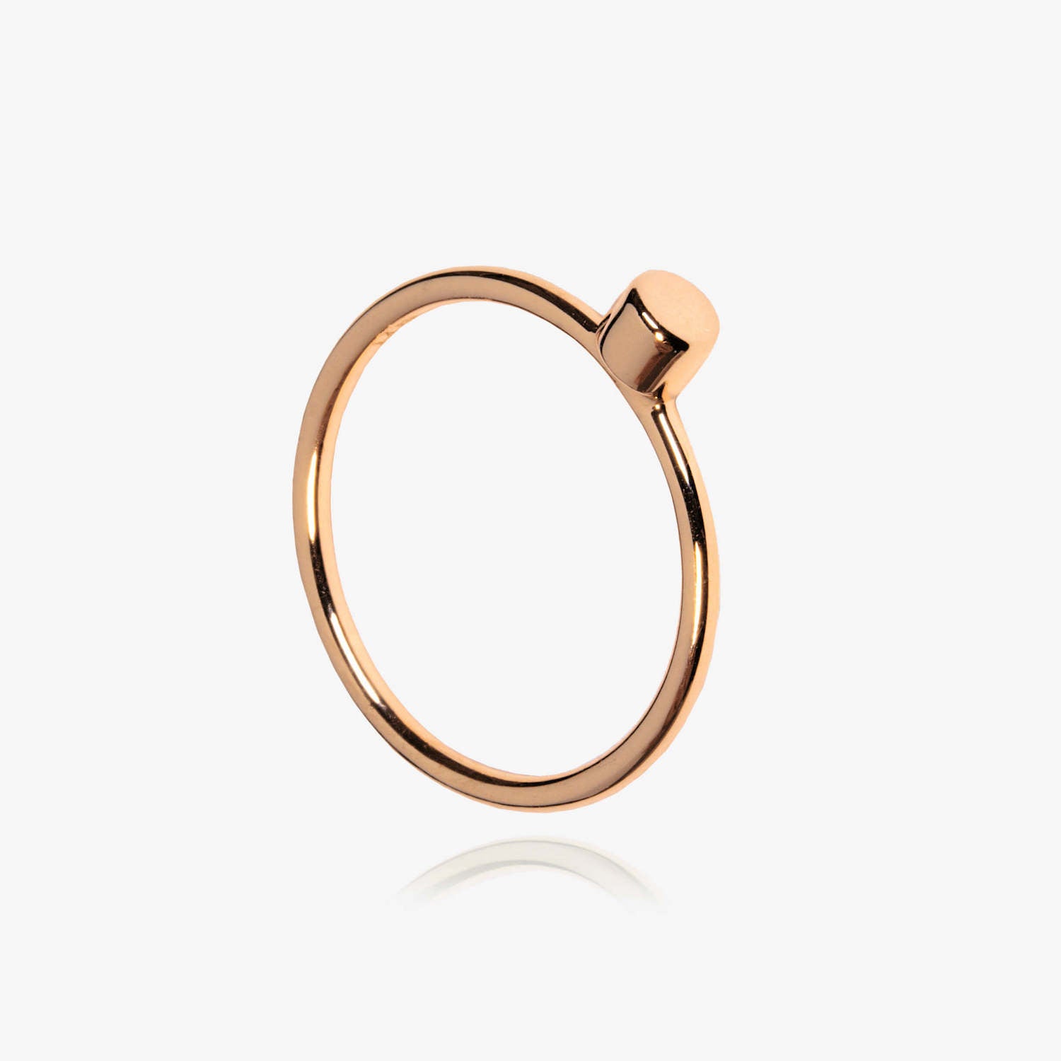Rose Gold Matthew Calvin simple dot ring photographed on a white background