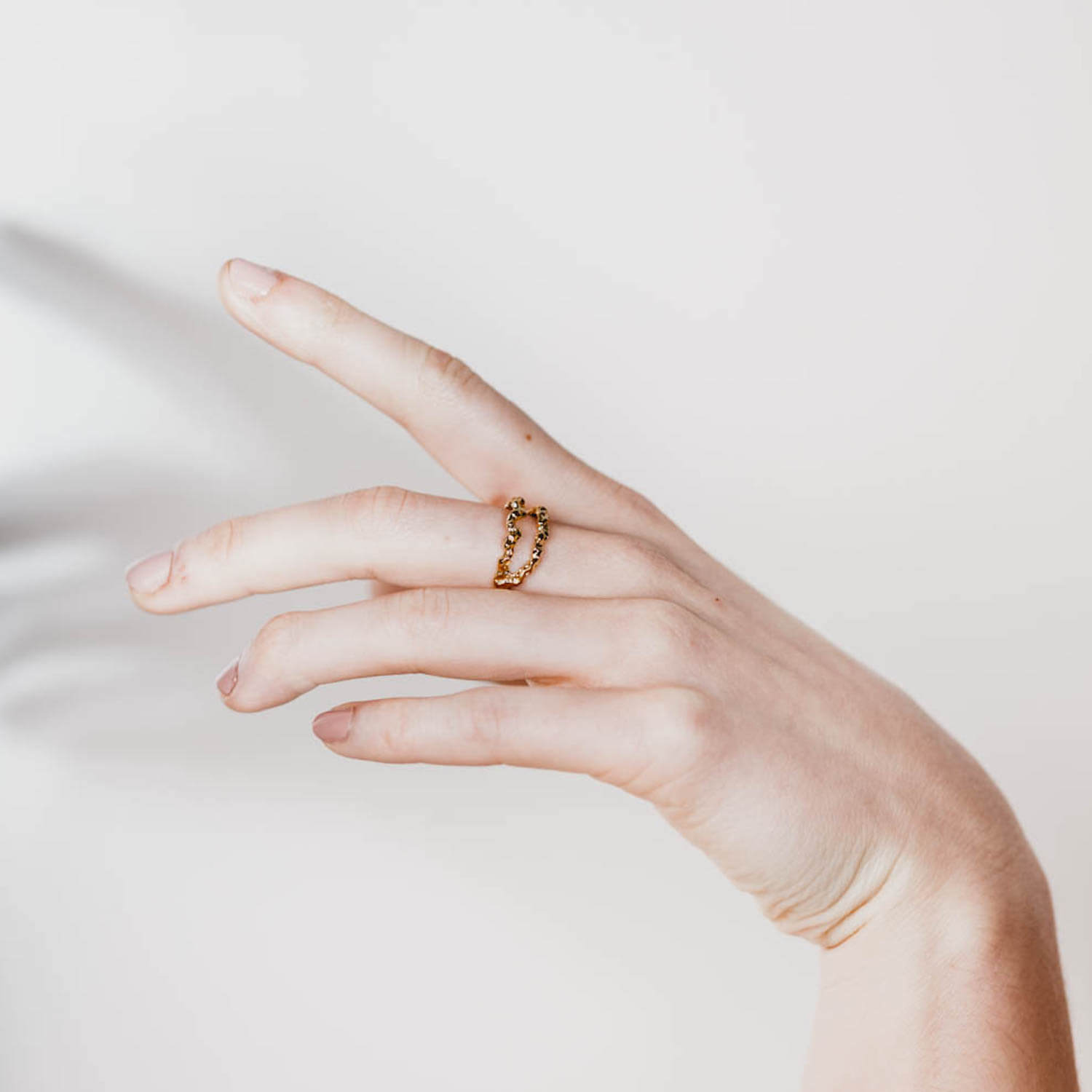 Model's hand wearing one Double Meteor Ring with rose gold vermeil plating