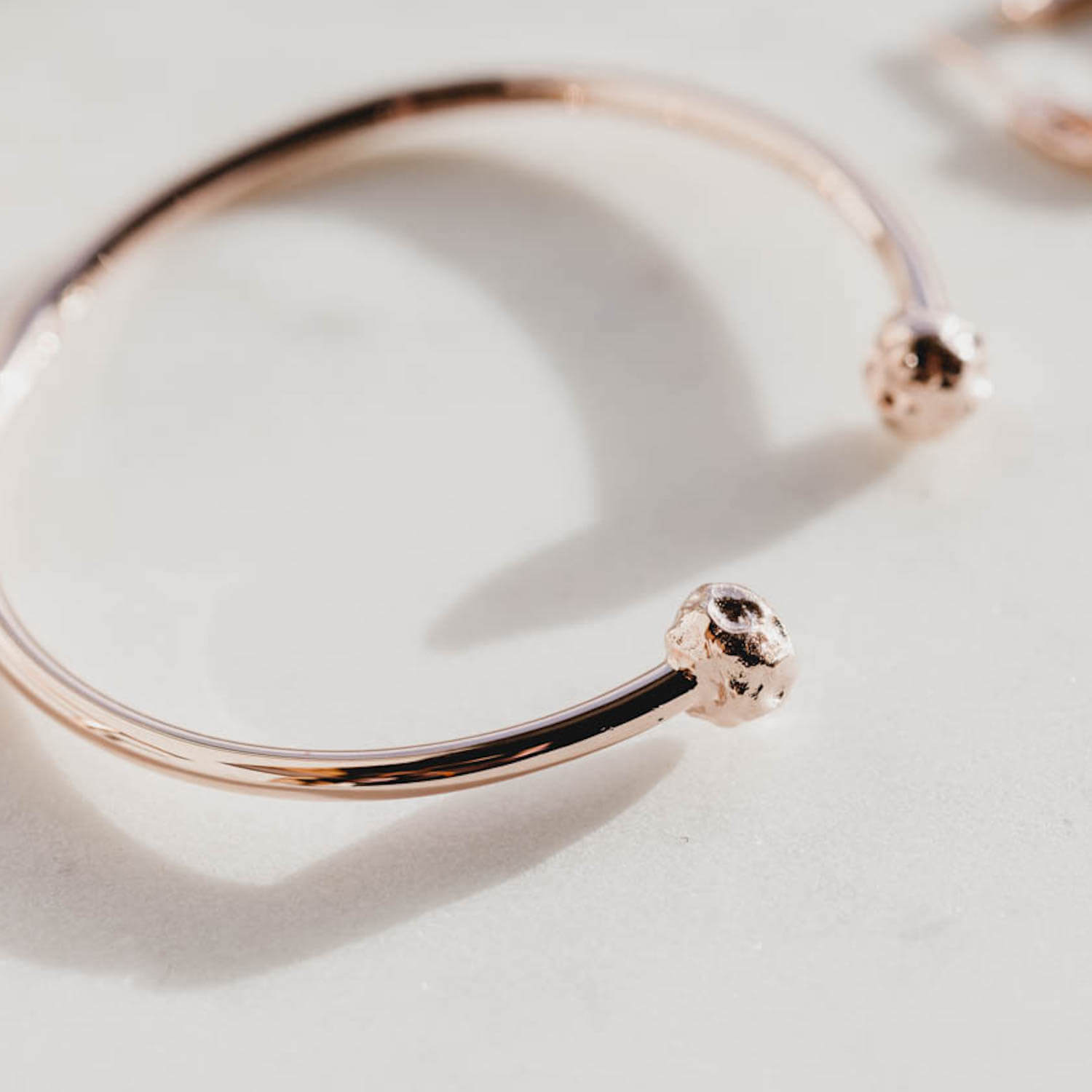 Detailed close up of open meteorite bangle with textured charms