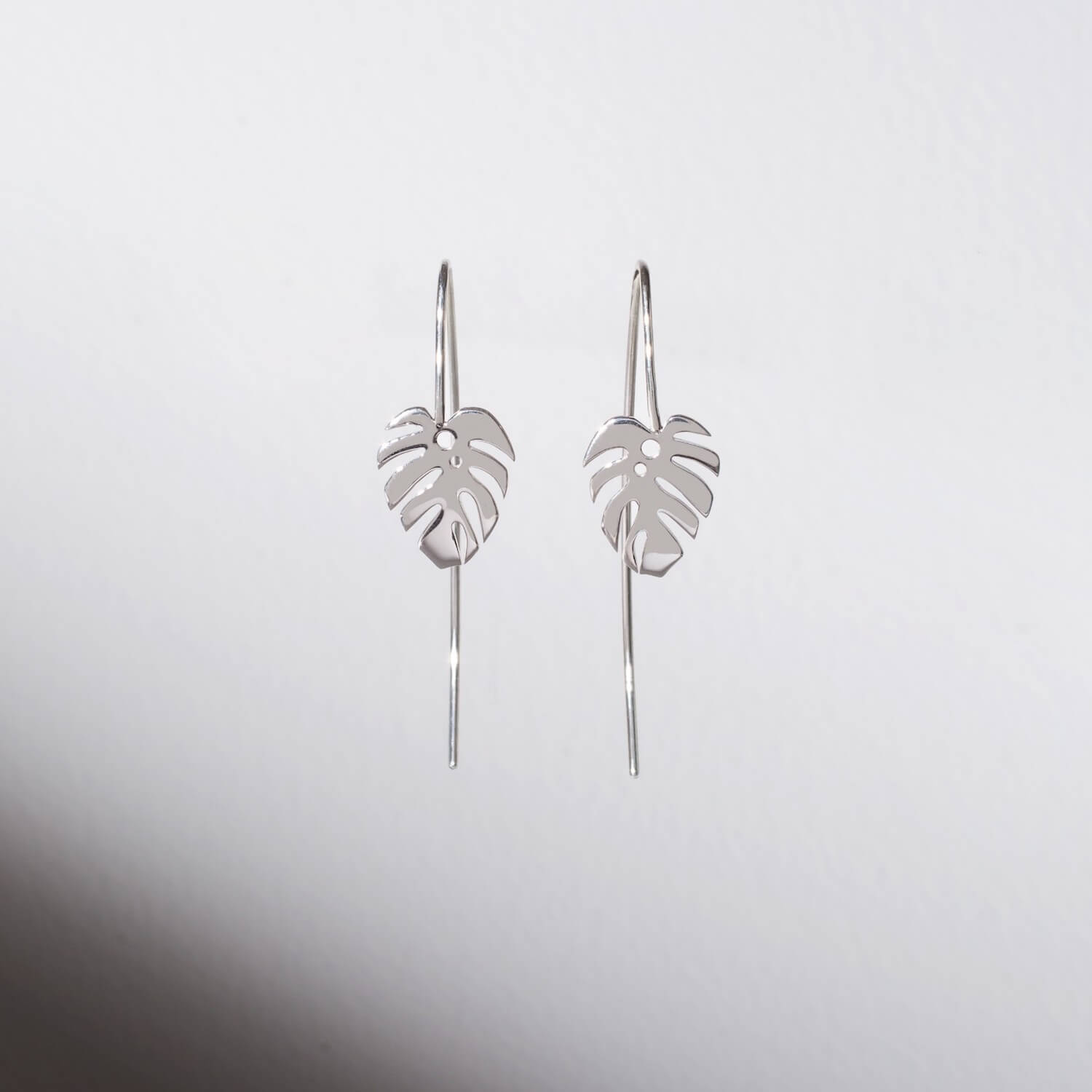 A pair of silver dropback earrings with cheeseplant charms