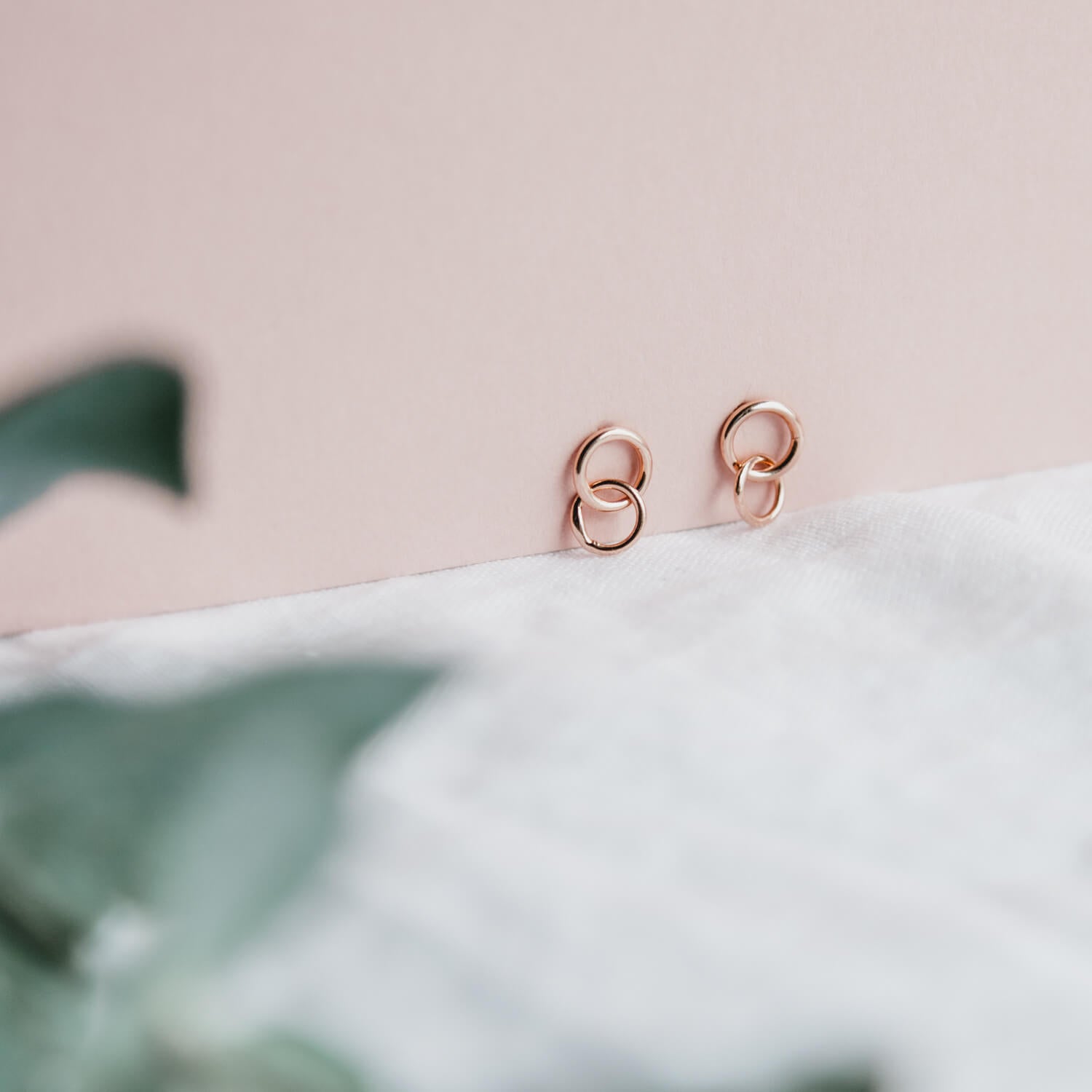 Close up of rose gold studs with interlocking ring detail