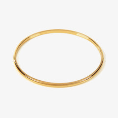 Close up of a gold bangle on a white background