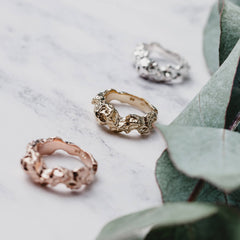 Three rings side by side, one in silver, one in rose and one in gold