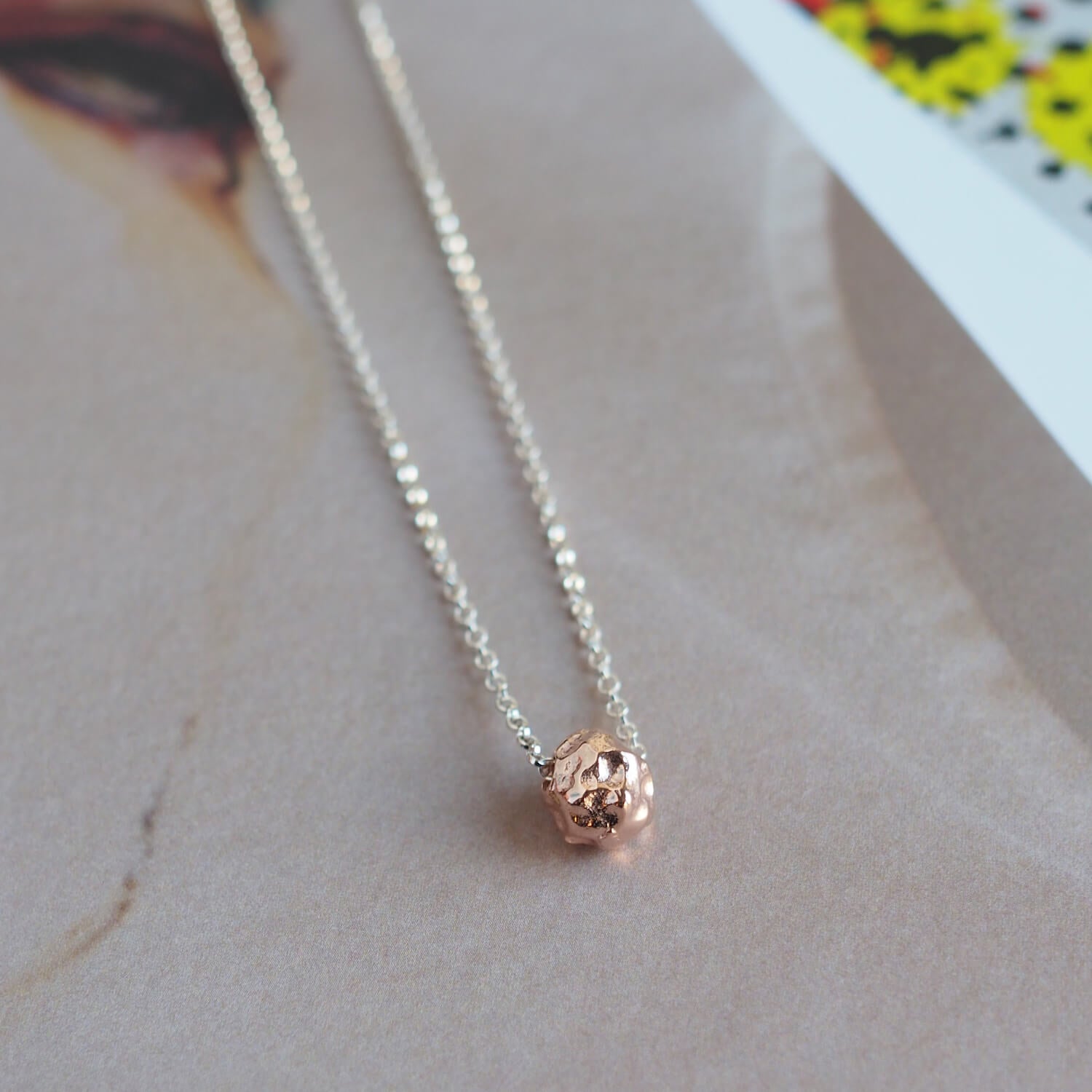 Close up of meteorite style charm in rose gold on silver chain by Matthew Calvin Jewellery
