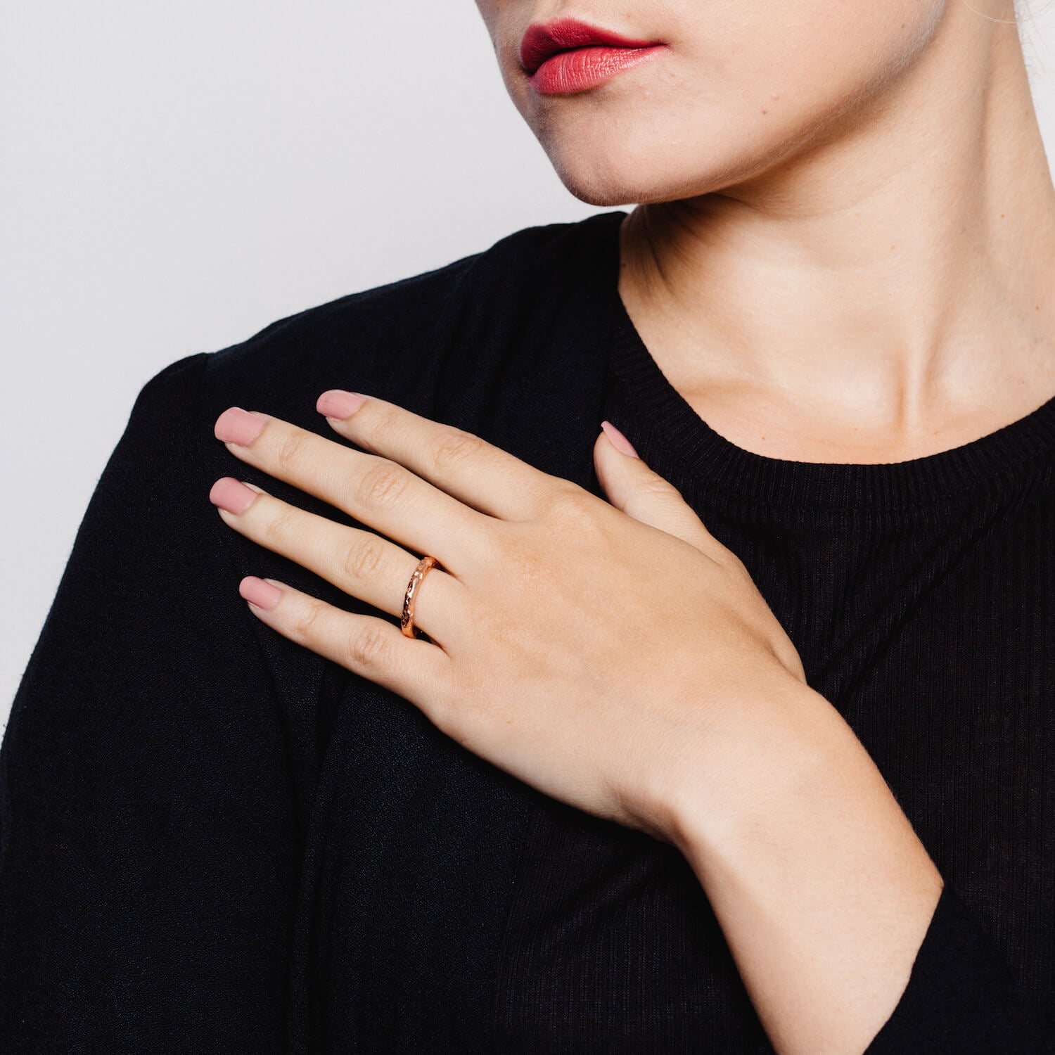 Model wearing rose gold textured ring with meteorite style details