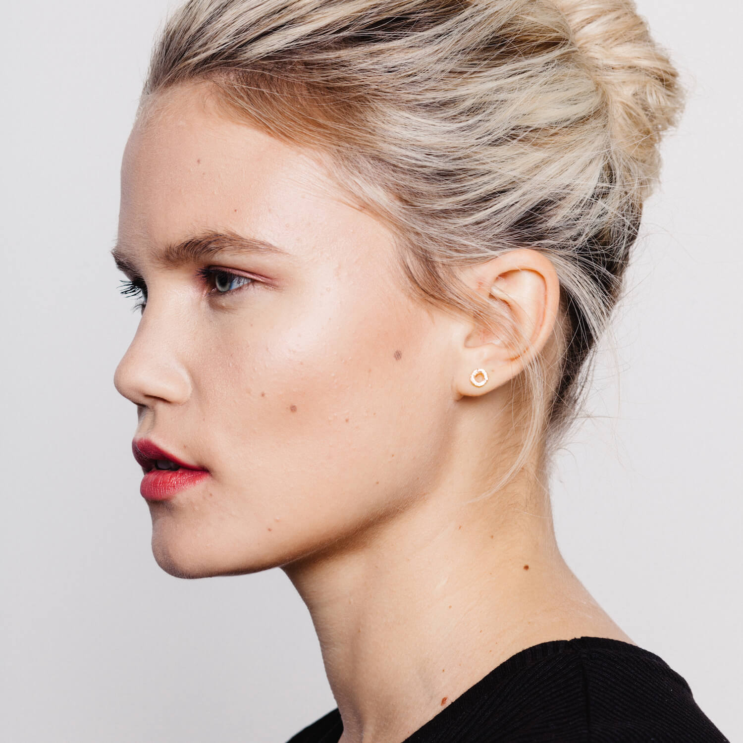 Model wearing round earrings with textured detailing