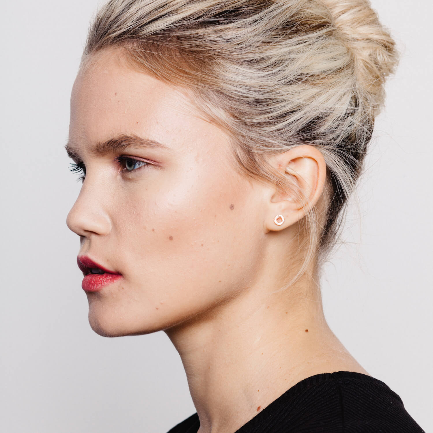 Model wearing round earring with textured detail