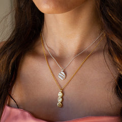 Two necklaces on a model, one in solid sterling silver and one in 18 carat gold plating