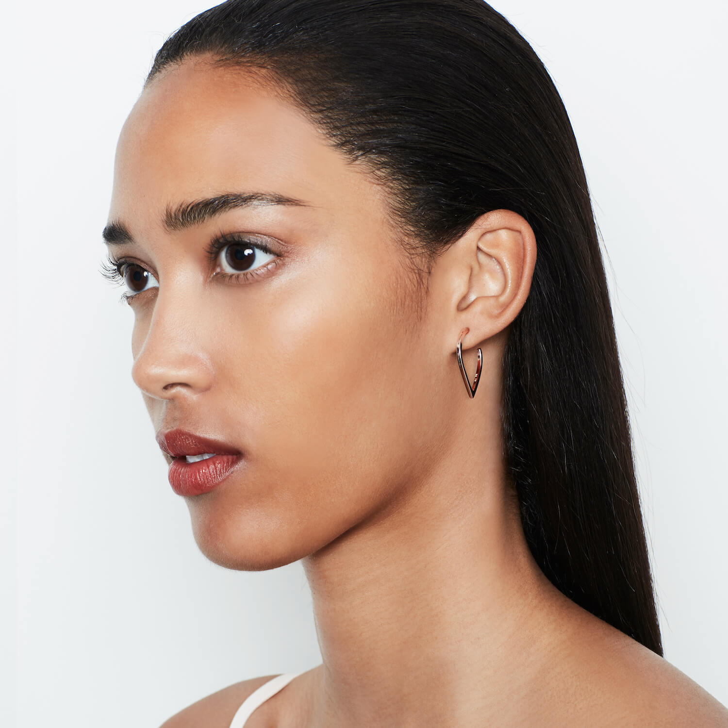 A woman wearing Point Hoops in gold