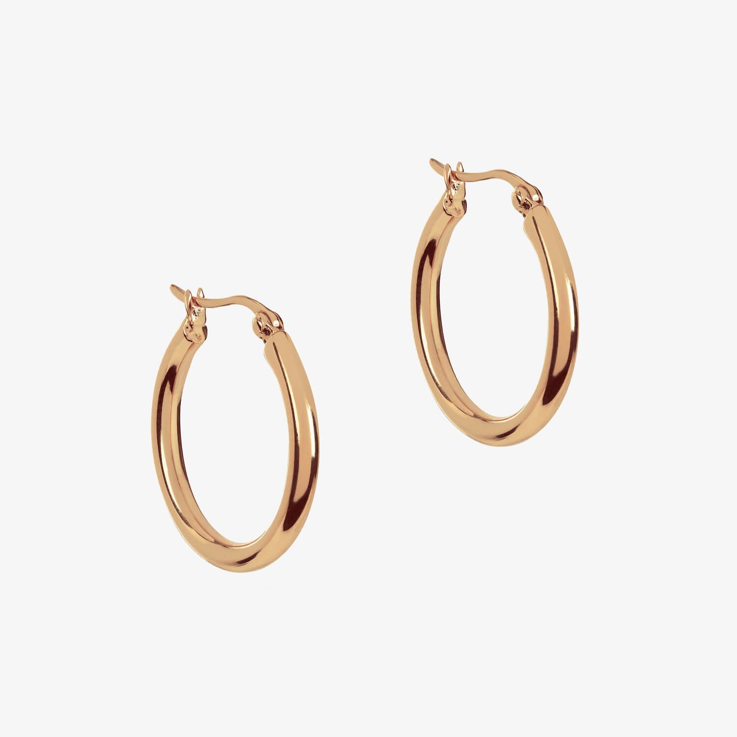 Large rose gold hoops on a white background