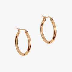 Large rose gold hoops on a white background
