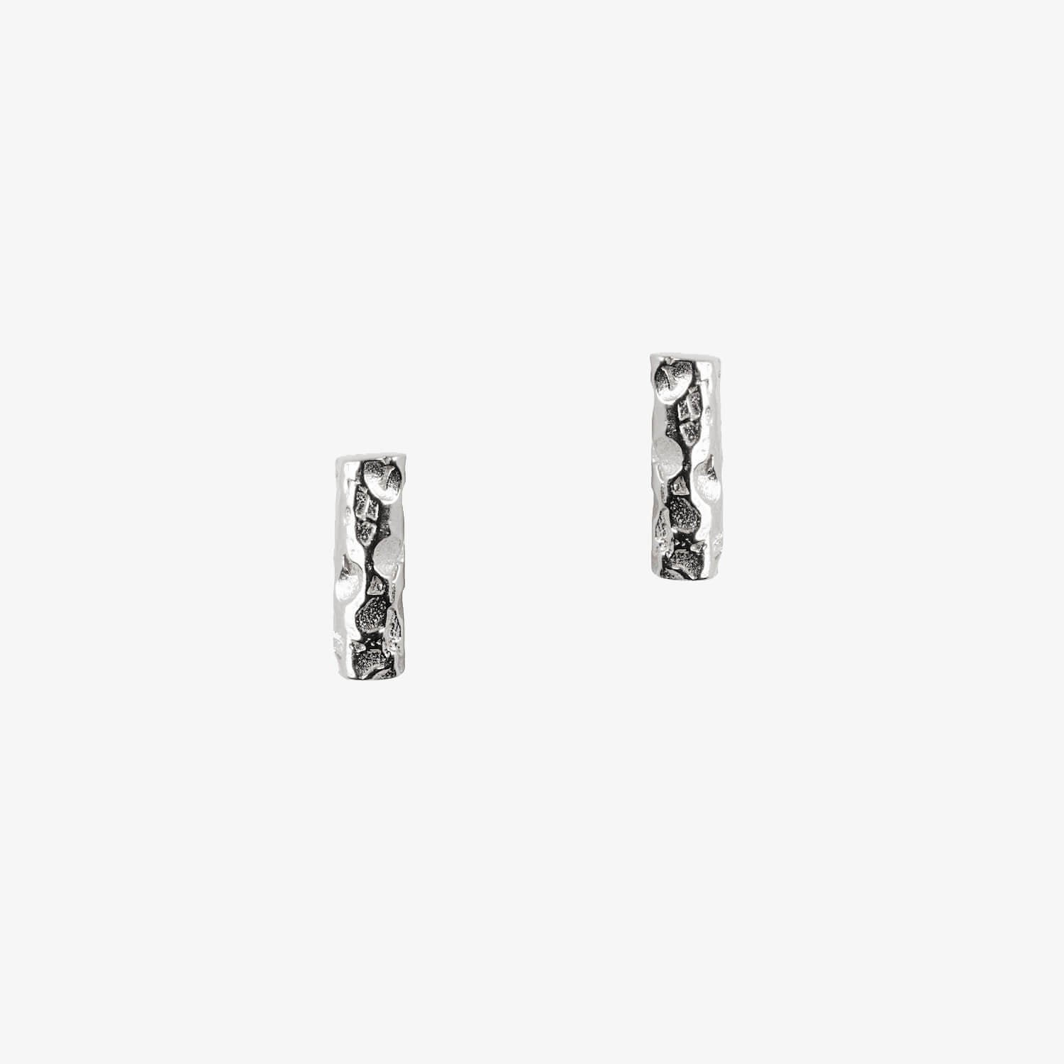 Silver earrings in a bar shape with textured meteorite style finish