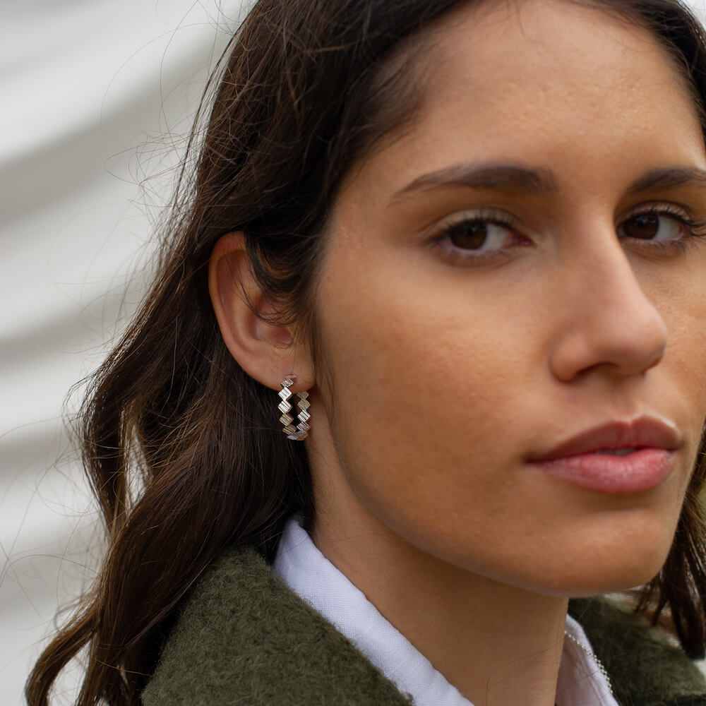 Telos Charm Hoops being worn by a woman in a green coat