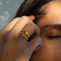 Close up of model wearing two gold rings with textured detailing